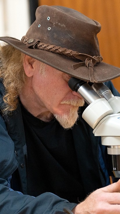 Mature Student Looking Through Microscope