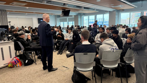 Students in a packed lecture room listening to a lecturer.