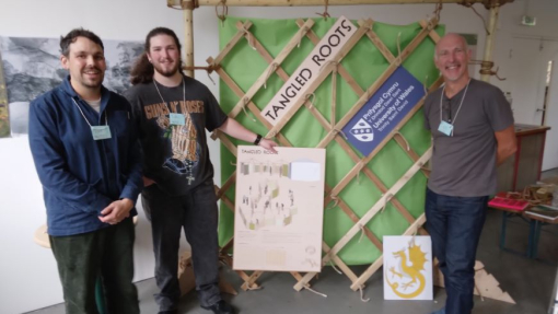 Two students and a lecturer standing beside their winning design.
