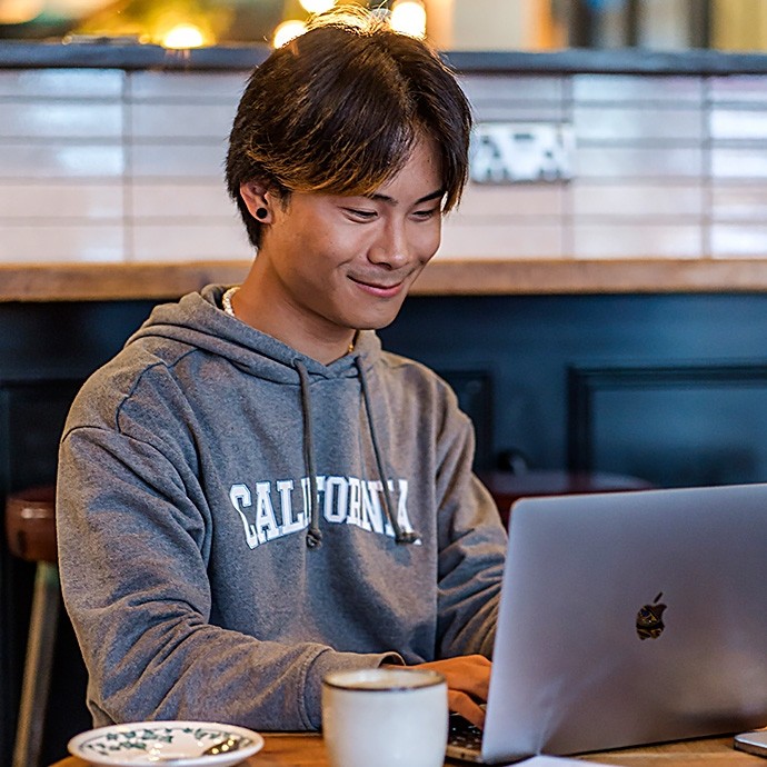 A young man using a laptop in a café.  