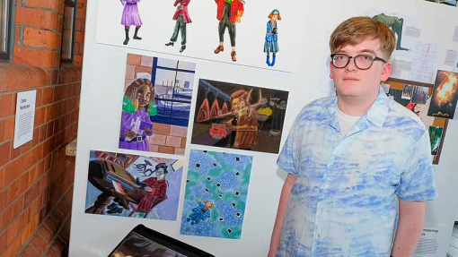 Blaine Henderson stands next to a display of his illustrations.