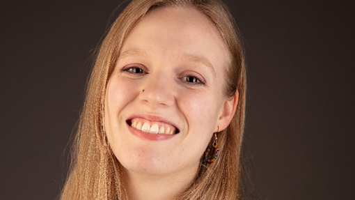 Jojo Bishop smiles for the camera in a studio photo.