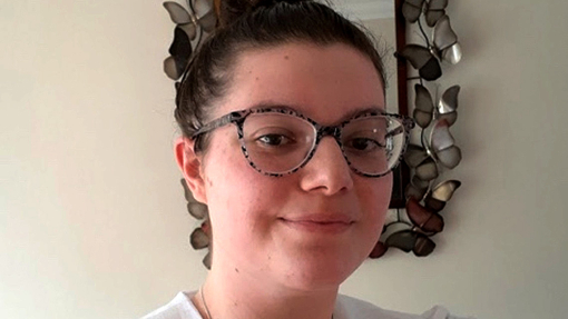 Sophie Larcombe smiles for a selfie in front of a mirror edged with metal butterflies.