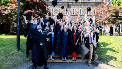Graduation 2025 on Carmarthen campus throwing hats in the air