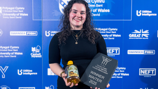 Image of Arwen holding a bottle of rum and trophy