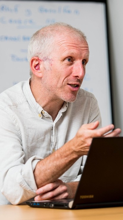 Staff member in discussion with laptop in front of him