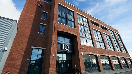The glass and red brick exterior of the IQ building.