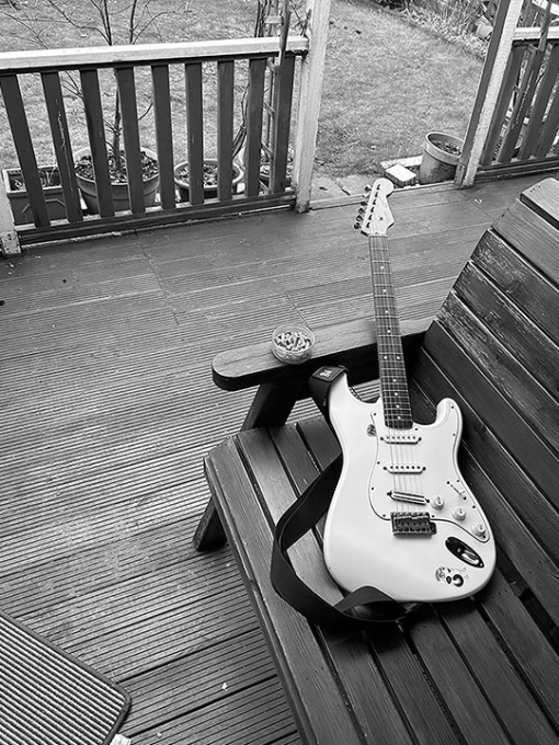 black and white image of a guitar on a bench with and astray