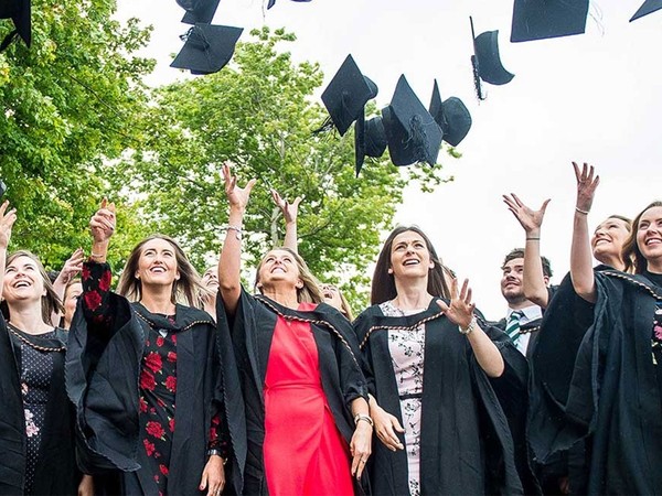 a group of students throwing hats in the air