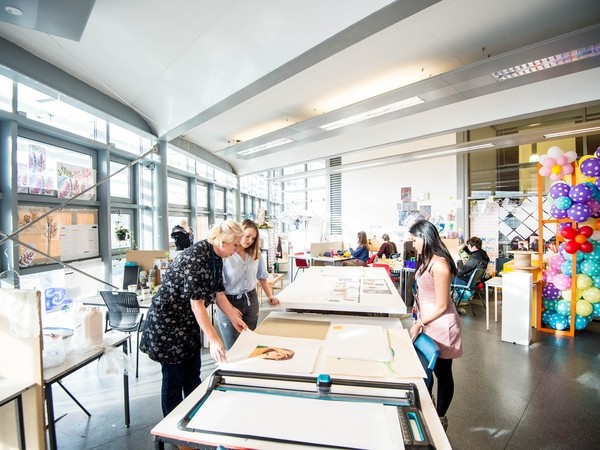 students in a light classroom doing art