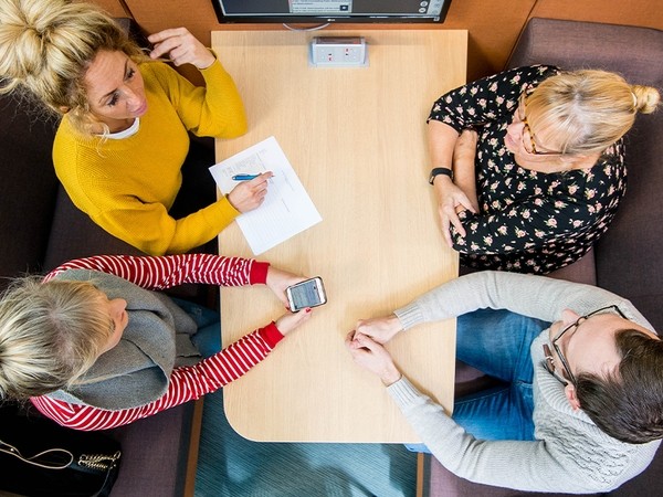 Aerial shot of 4 students sitting in a booth