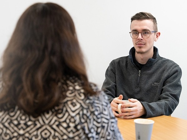 Students chatting at a table with a coffee