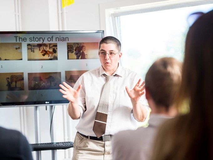 Lecturer presenting in front of a screen