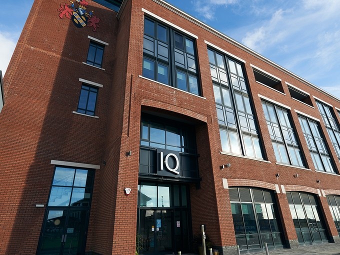 The glass and red brick exterior of the IQ building.