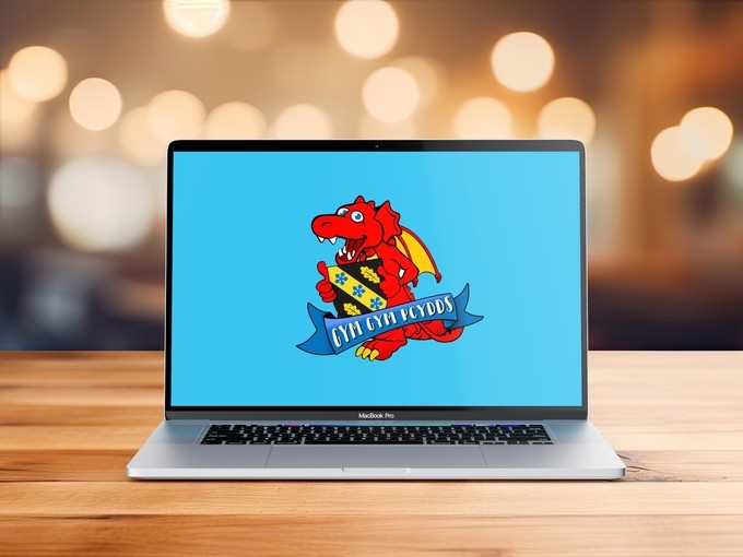 Laptop on a table displaying the Y Gym Gym logo