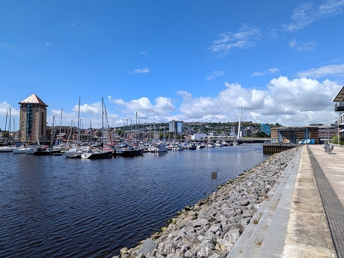 View across rows of yachts moored in the Tawe on a sunny day.