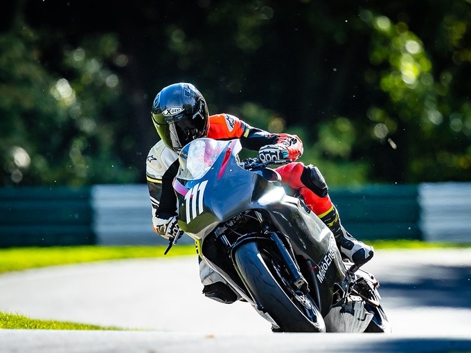 Ilias leans right on his motorbike as he races round a tight corner.
