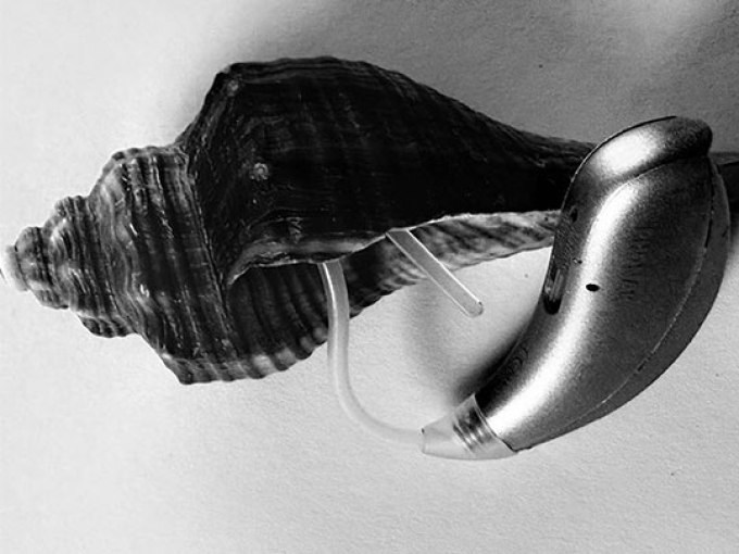 black and white image of a shell with a hearing aid