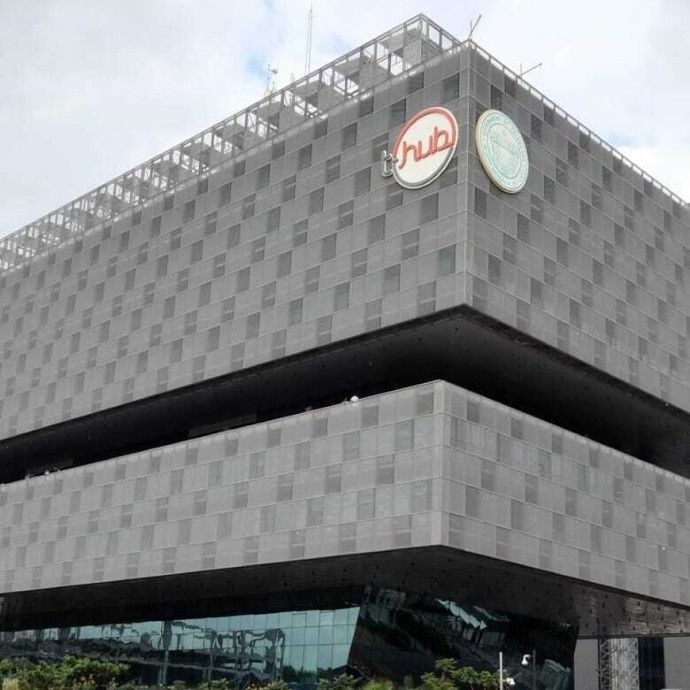 T-Hub headquarters in Hyderabad; a massive grey building consisting of two blocks overshadowing a glass-walled ground floor. 