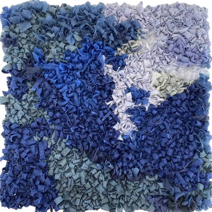 Rag rug with an abstract design using material in shades of blue. 