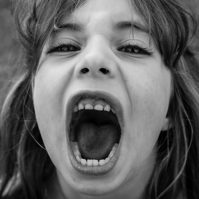 Black-and-white photograph showing a girl screaming up towards the camera.