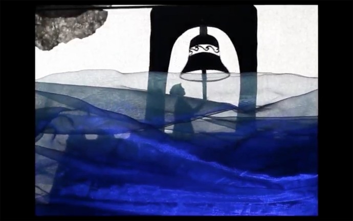 A black papercut silhouette rings a bell hanging from a tower; the foreground is dominated by rolls of indigo, representing flood waters.