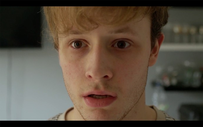 A young man stares grief-stricken towards the camera.