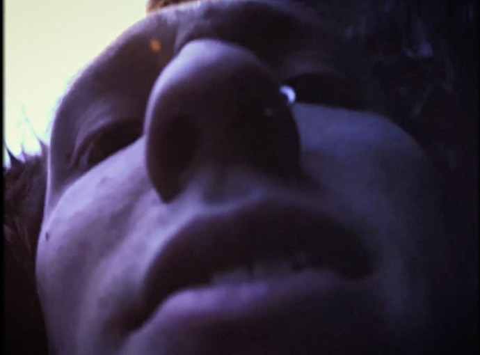 A low-angle extreme close-up of the face of a young man looking scared.