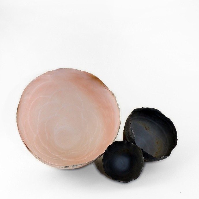 Three thin and fine ceramic bowls: the inside of the largest has a pink and white sheen like the interior of a clam shell; the other two are dark blue and white like mussels. 
