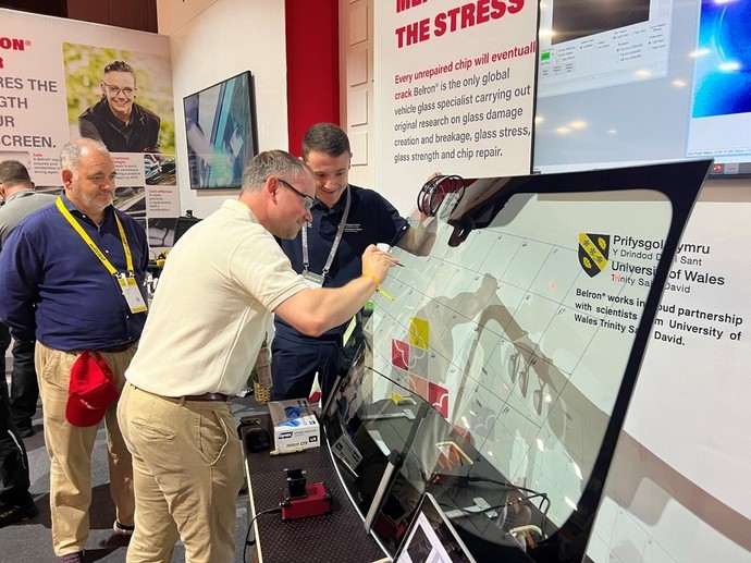 Jordan Jenkins from UWTSD encouraging a client to damage a windscreen on the trade stand at the Belron conference in Lisbon
