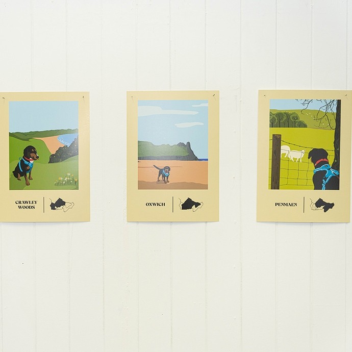 Three small posters showing a black-and-tan dog at three different locations – Crawley Woods, Oxwich and Penmaen; the style recalls vintage Great Western Rail holiday posters.