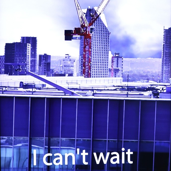 Poster in different shades of purple showing a cityscape with a large crane and underneath the words: I can't wait.