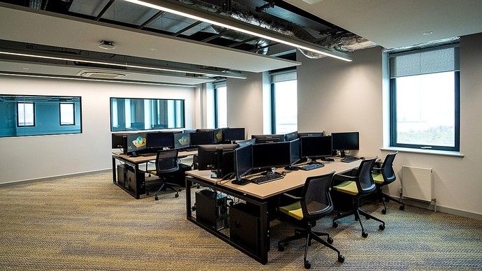Twenty PCs on desks in a bright modern room. 