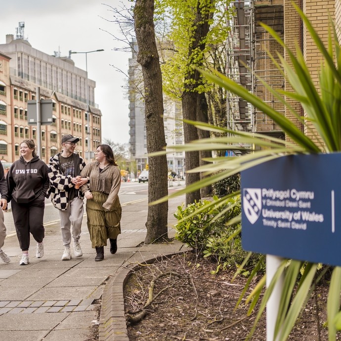 Four students walking outside Cardiff campus 