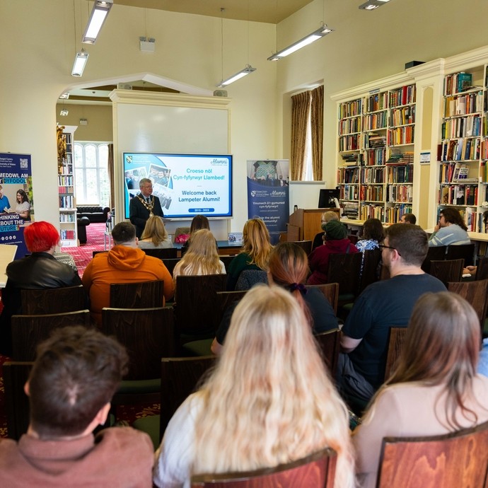 people sitting down at an Alumni presentation