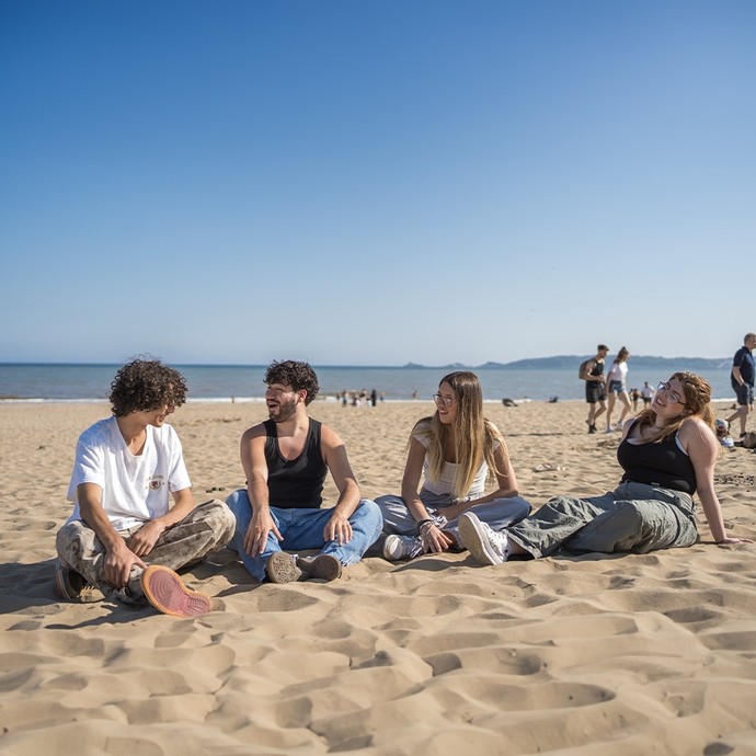 Students sitting on the beach