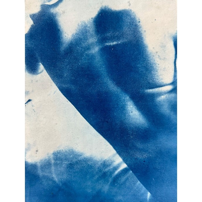 A cyanotype showing the back of a male nude set against an ambiguous background, suggestive of ripples in water or fabric. 